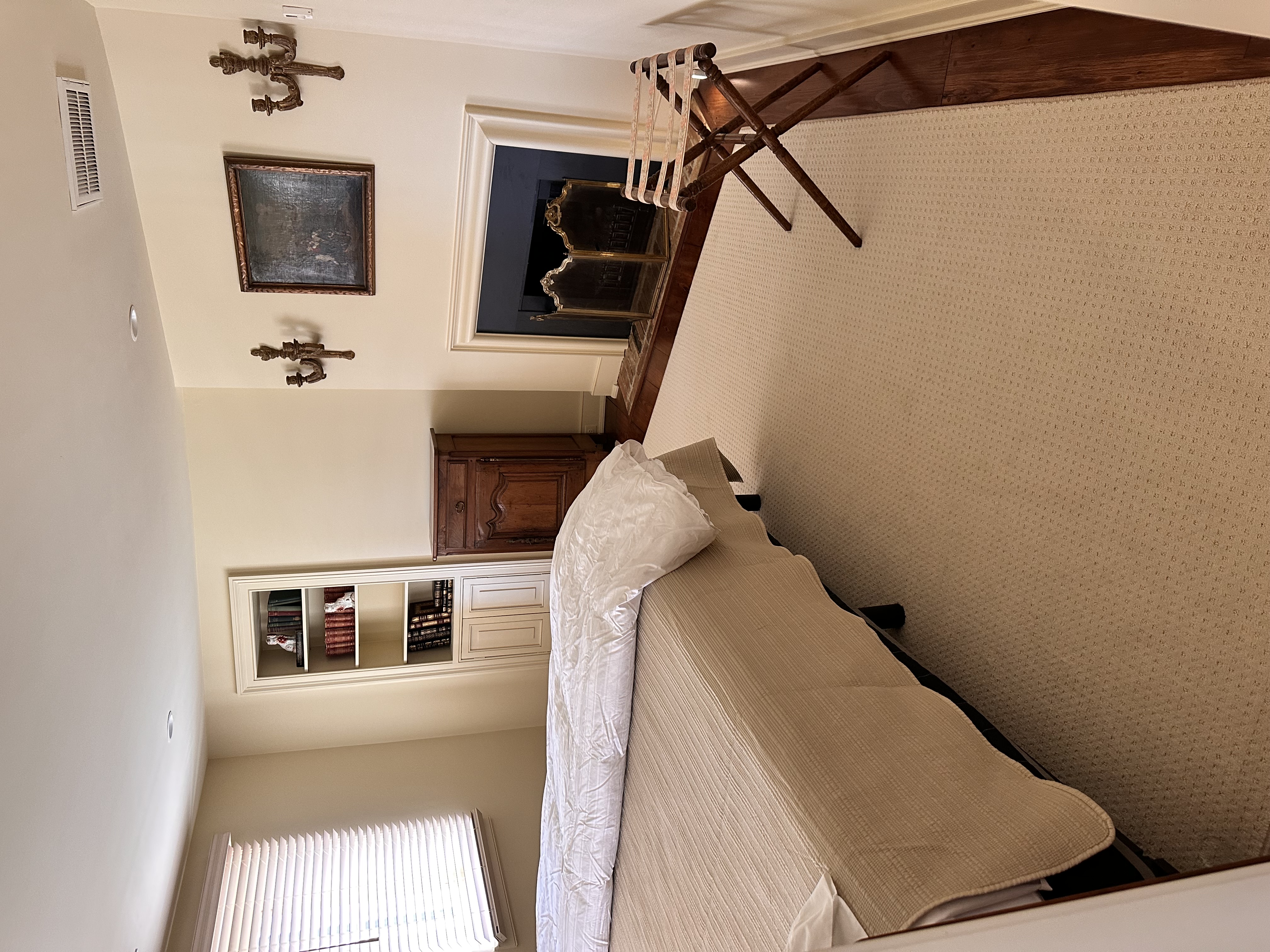 side of king-sized bed and view of chest and electric fireplace