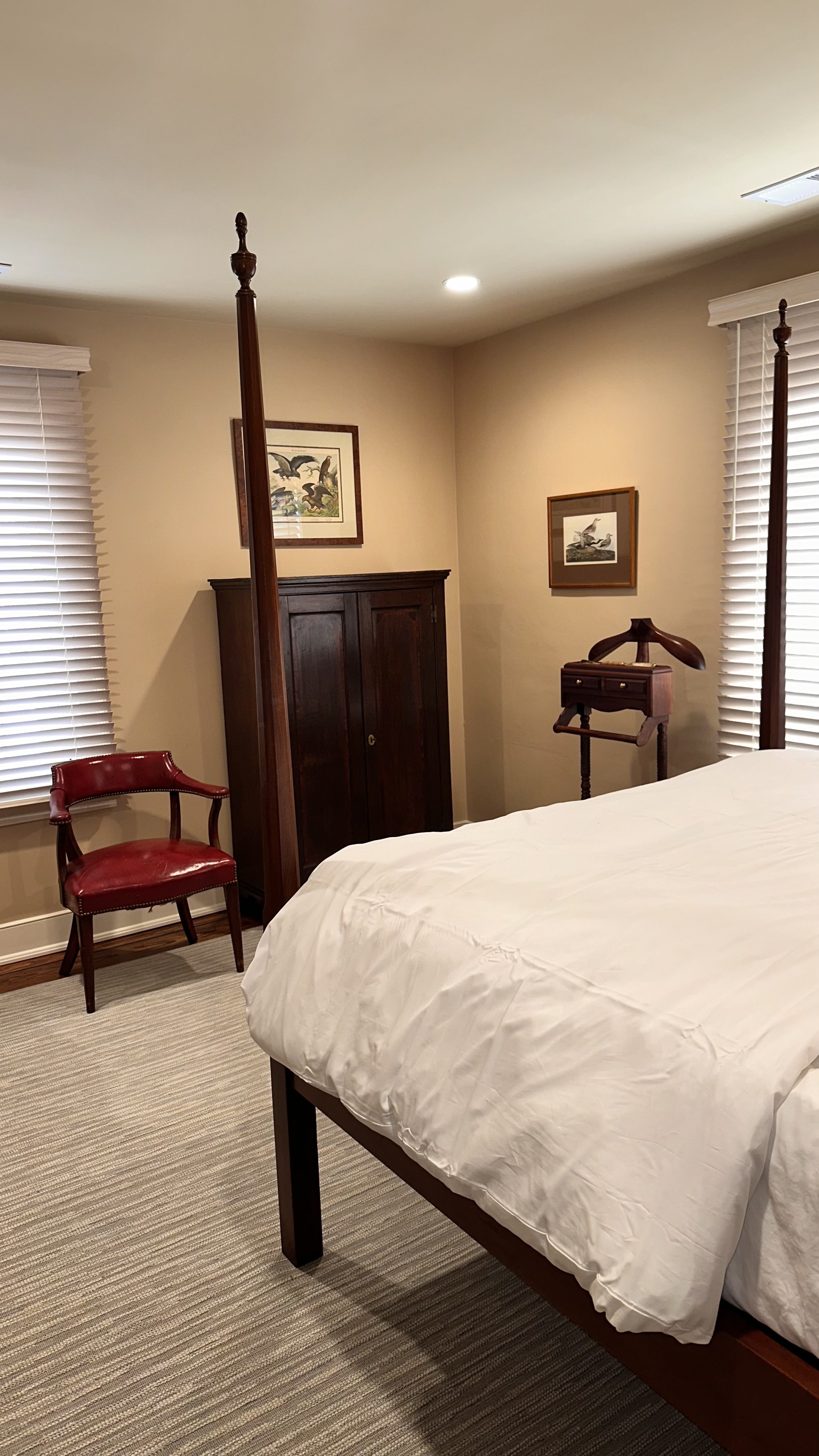 side view of queen pencil post bed and chest with chair beside it
