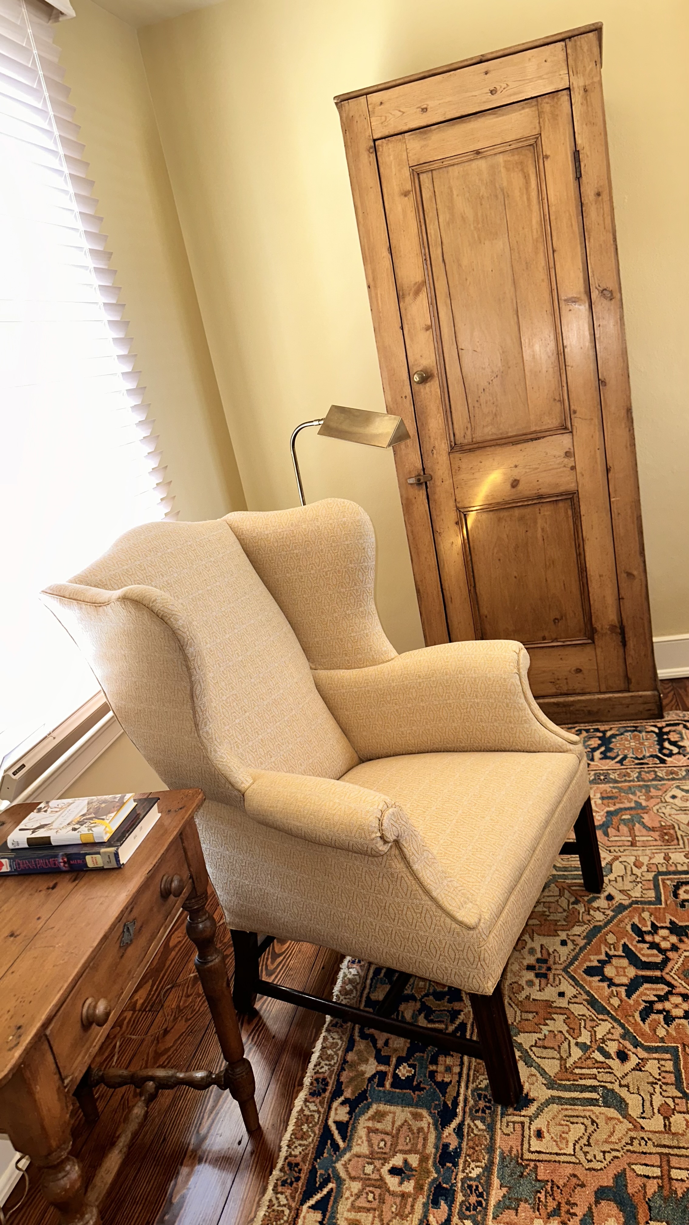 wingback chair with reading lamp side table and small armoire