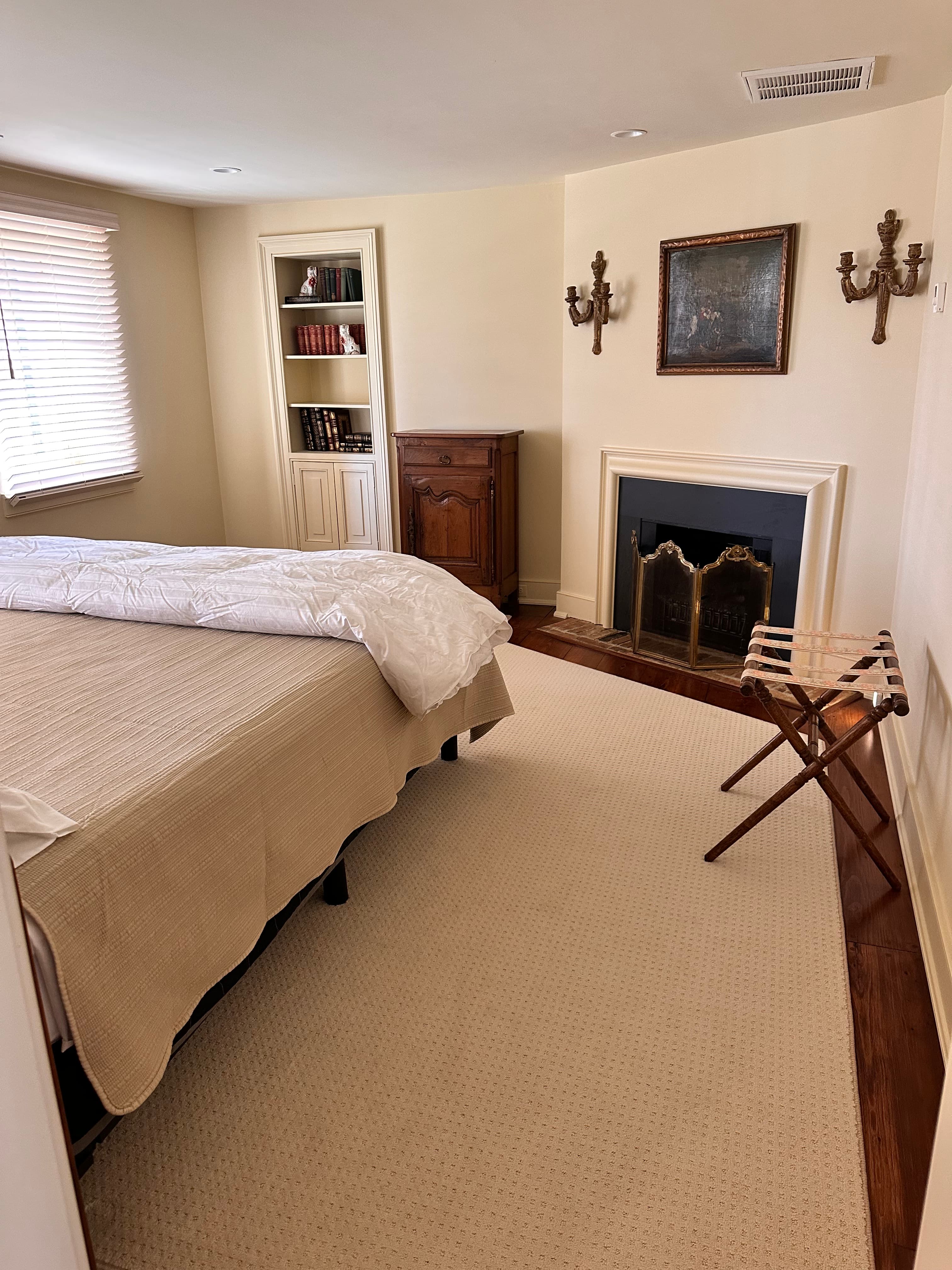 side of king-sized bed and view of chest and electric fireplace