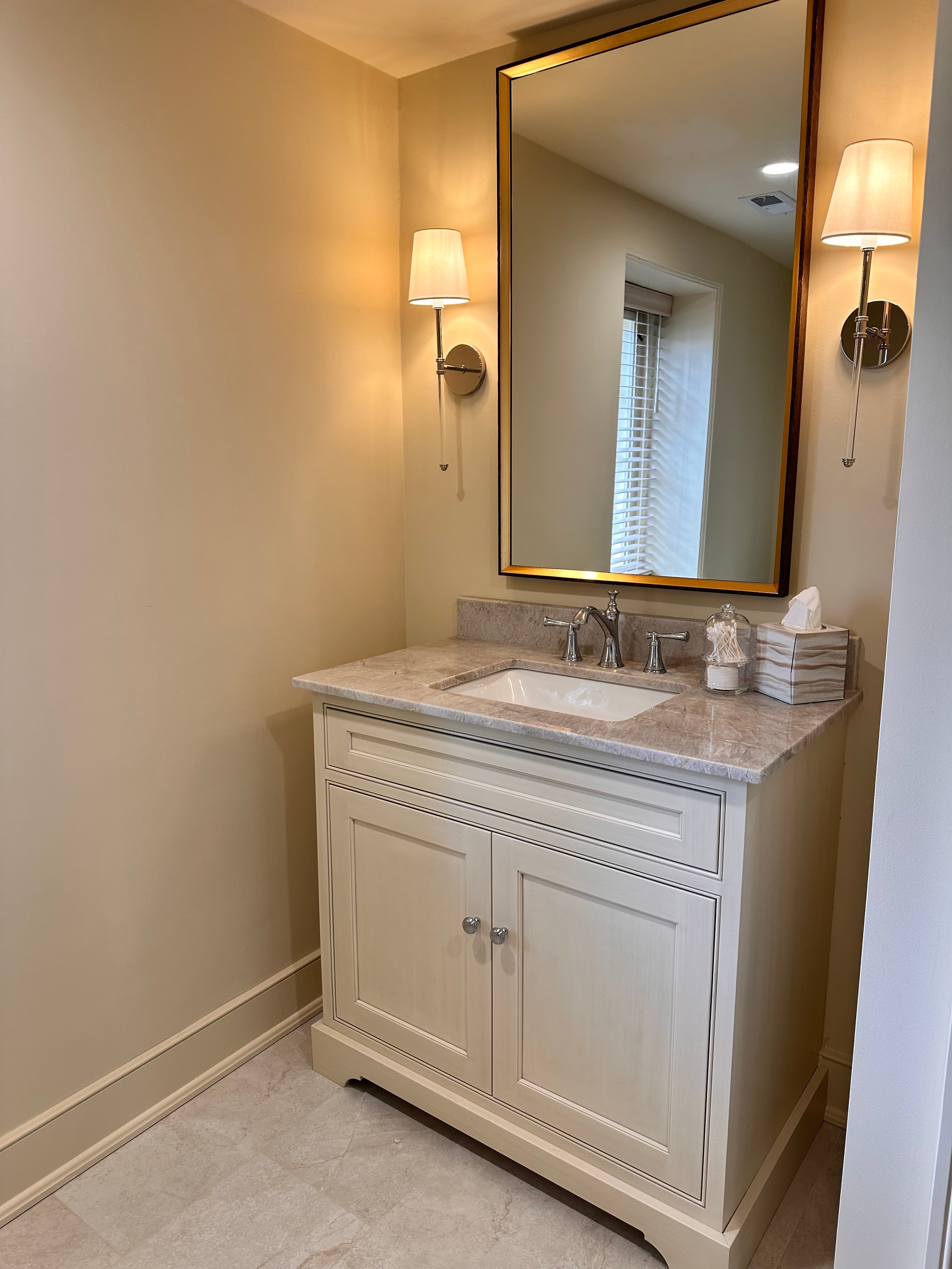 single vanity with sconces on either side of mirror