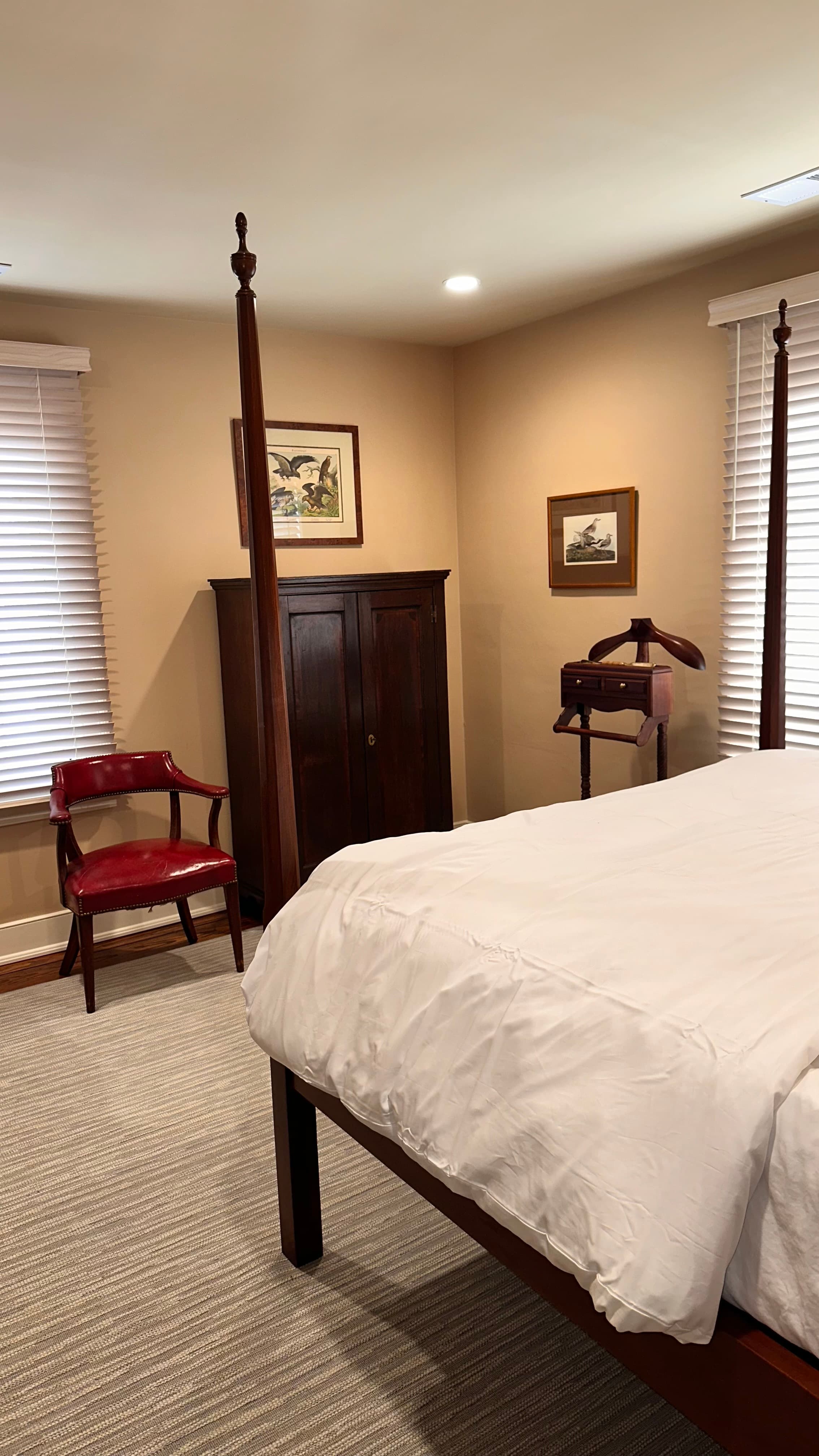 side view of queen pencil post bed and chest with chair beside it