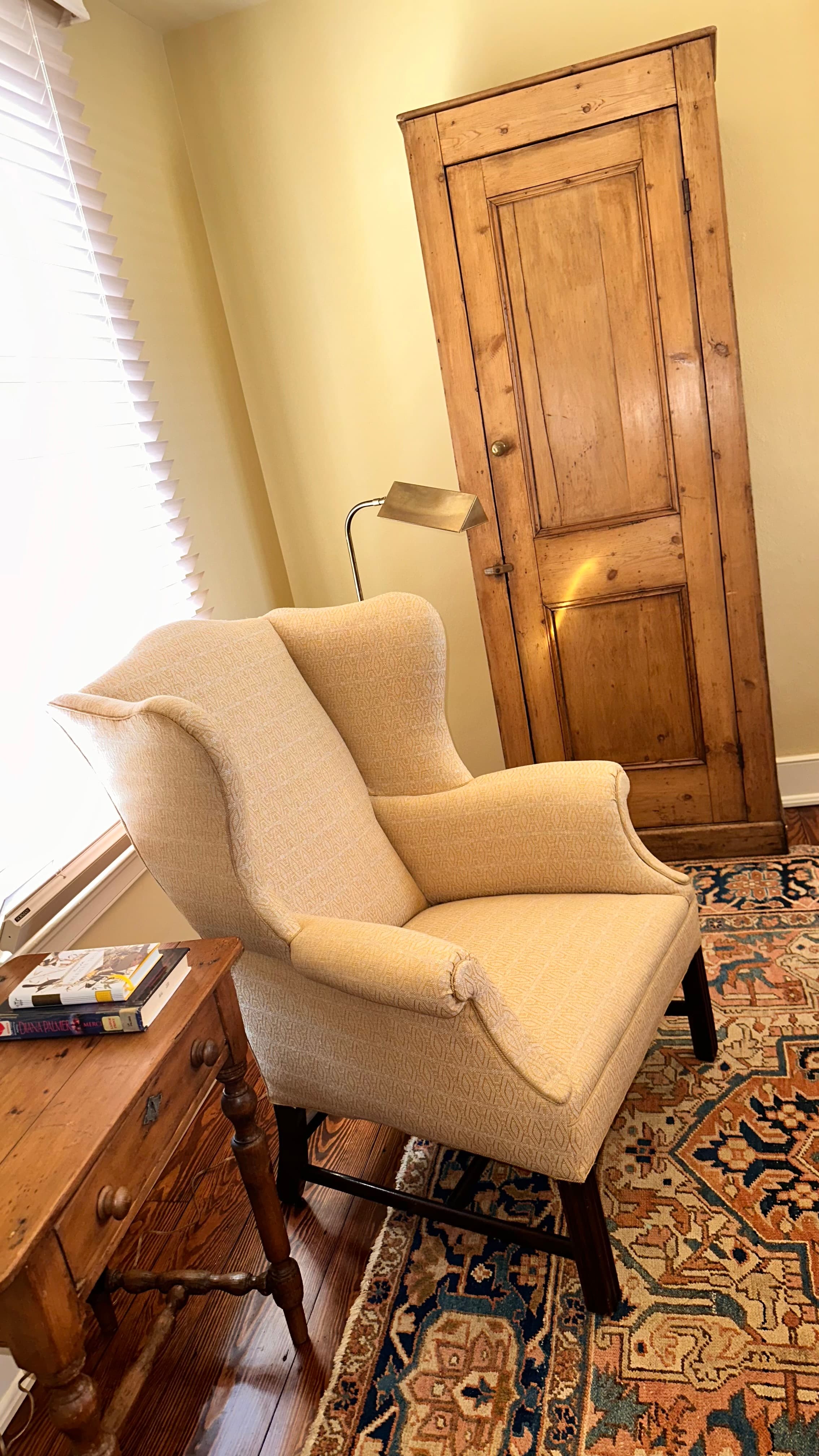 wingback chair with reading lamp side table and small armoire