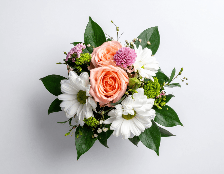 A bouquet featuring pink roses, white daisies, and various greenery.