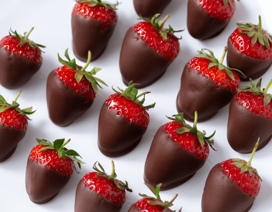 A plate of chocolate-covered strawberries arranged neatly.