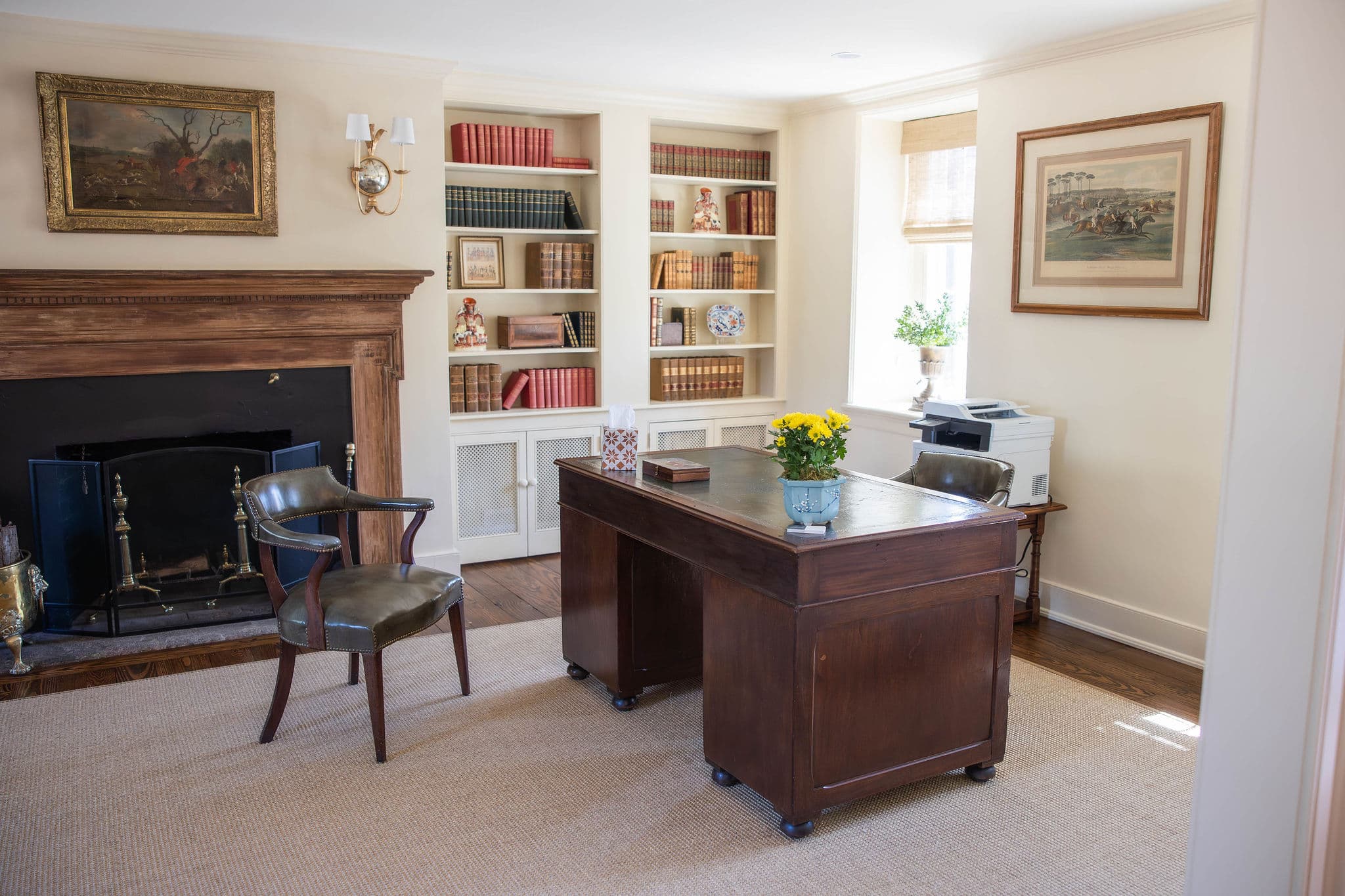 A cozy office featuring a wooden desk, a chair, and shelves filled with books and decorative items.